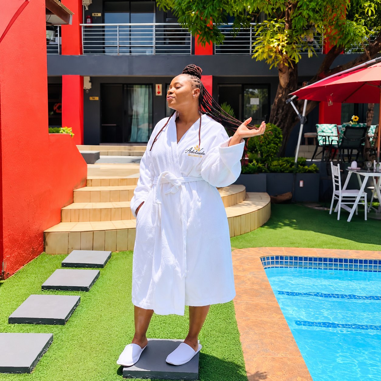 A guest in a spa robe beside the swimming pool