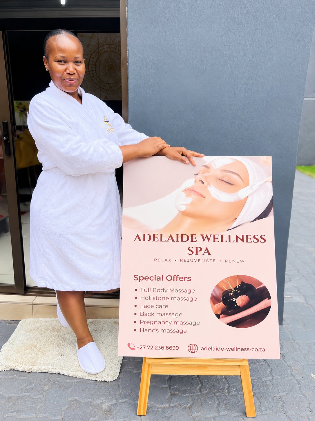 A guest beside the Adelaide Wellness Spa signboard
